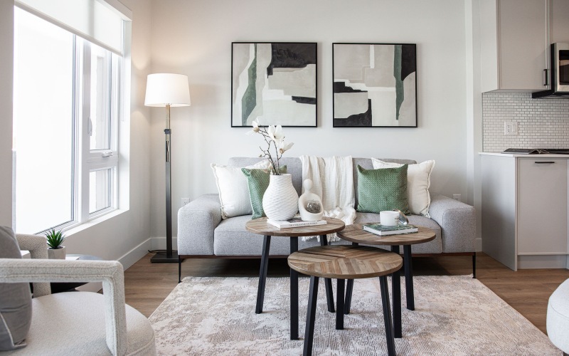 a living room with a white couch and a table with a lamp