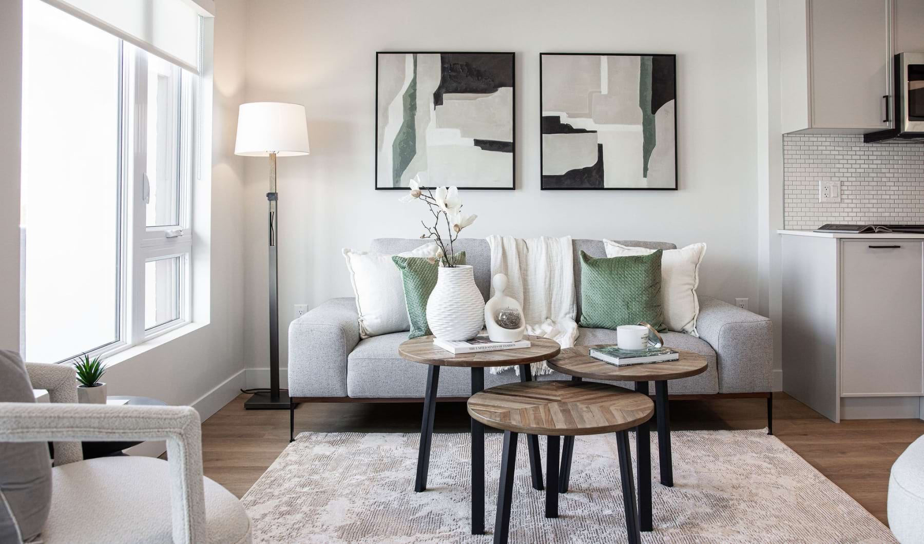 a living room with a white couch and a table with a lamp