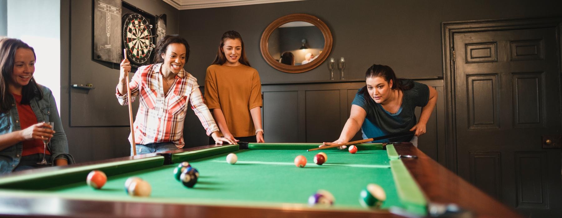 a group of people playing pool